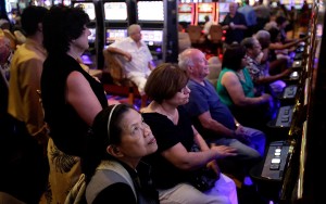 People gamble at the casino at the Aqueduct Racetrack in the Queens section of New York, Tuesday, Aug. 7, 2012. More than a billion dollars bet by nearly a million customers last month is the latest evidence that the "racino" at Aqueduct Racetrack in New York City is capitalizing on its prime location and drawing dollars and gamblers from neighboring states' casinos.  (AP Photo/Seth Wenig)